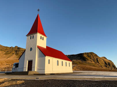 Reyniskirkja Church. Red trim church with white exterior
