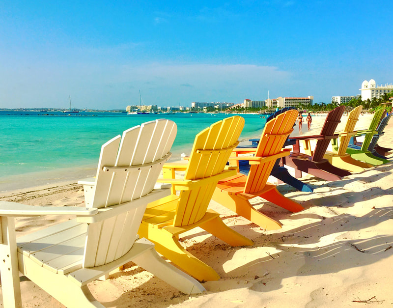 Adirondack chairs on a beach in Aruba